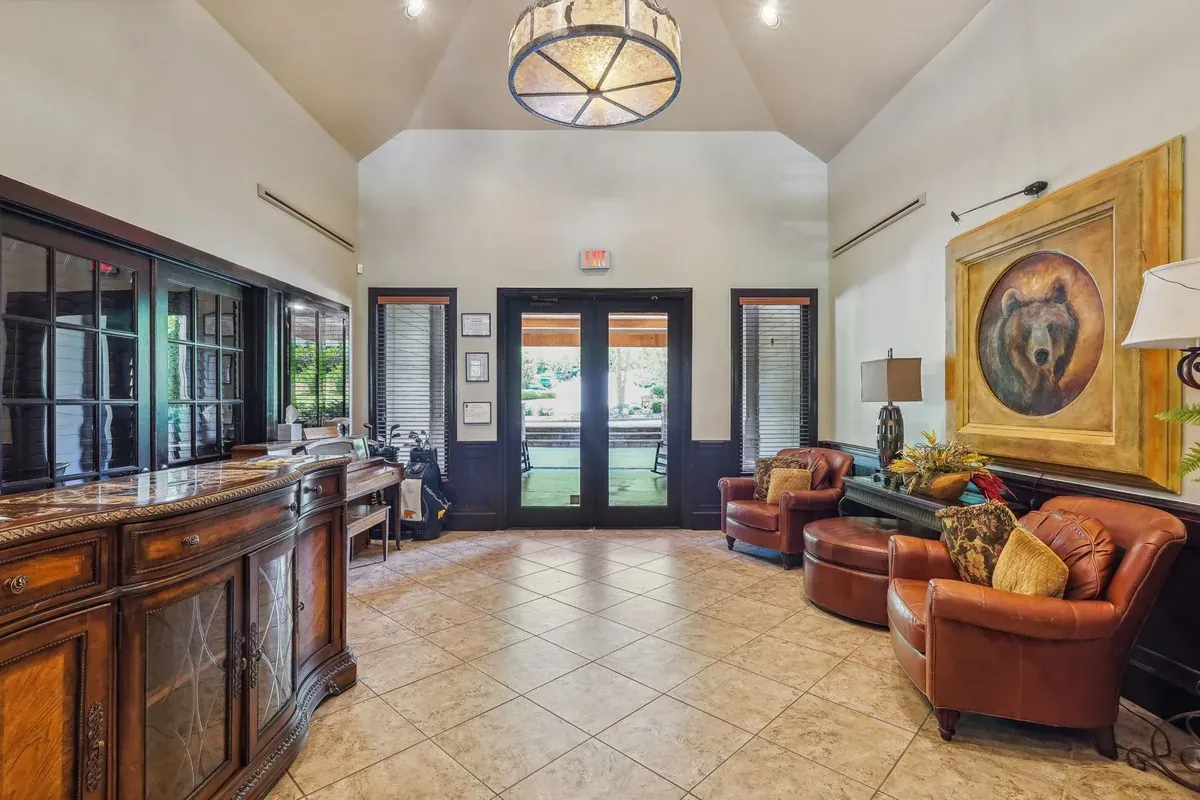 Clubhouse lobby with leather chairs, tall windows and framed bear artwork